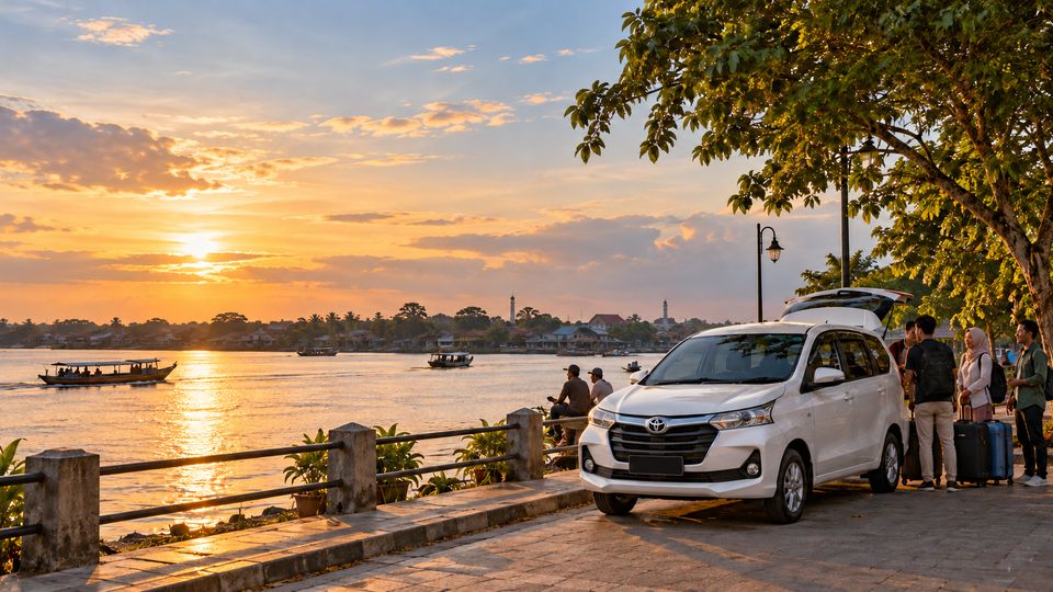 Penumpang menunggu travel di tepi sungai saat matahari terbenam